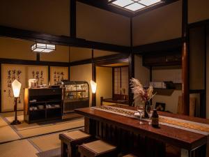 a room with a table and chairs and a room with writing at Chousenkaku Kameya in Shimo-suwa