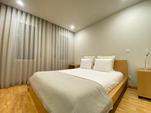 ヴィラ・ノヴァ・デ・ガイアにあるAtlantis Apartments by URの白い枕が付いた大きな白いベッドのある寝室 +42枚の写真