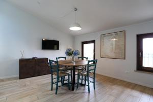 una sala da pranzo con tavolo e sedie in legno di Le Querce Apartments a Ronchi