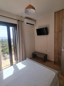 a bedroom with a white bed and a television at Villa Rodi in Galaxidi +33 photos
