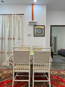 カジャンにあるHarith's Little Homestayの椅子2脚(テーブルの横に座る部屋)