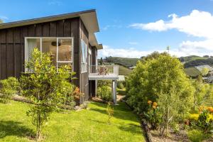 a house with a balcony and a yard at Vineyard Magic, Onetangi in Onetangi