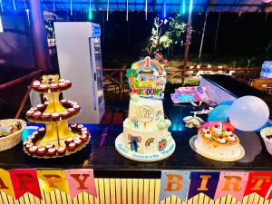 a table topped with a birthday cake and balloons at The Windchimes Retreat Coorg in Virajpet