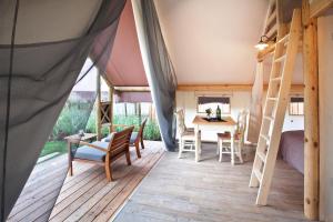 Zimmer mit einem Zelt mit einem Tisch und Stühlen in der Unterkunft Charming Slovenia - Herbal Glamping Resort Ljubno in Ljubno