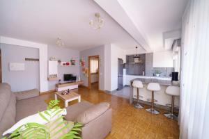 a living room with a couch and a kitchen at Antoxos Sacra Home II in Chantada