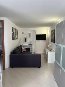 a living room with a black couch and a tv at Casa Caia in Genoa +11 photos