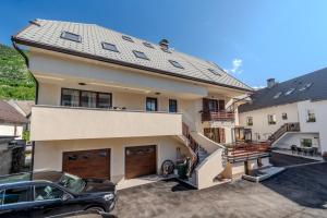 a house with a car parked in front of it at Penzion Hosnar, hiša Mišc in Bovec
