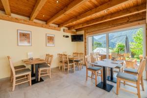 a dining room with tables and chairs and a large window at Penzion Hosnar, hiša Mišc in Bovec