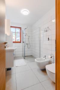 a bathroom with a tub and a sink and a shower at Penzion Hosnar, hiša Mišc in Bovec +17 photos