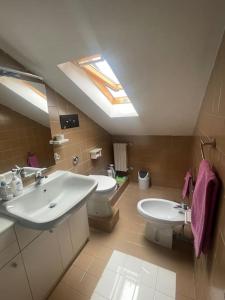 a bathroom with a sink and a toilet and a skylight at La piccola Baita in Folignano