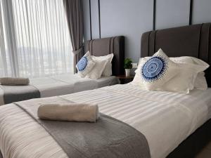 a bedroom with two beds with blue and white pillows at Tropicana 218 Spacious Luxury City 3BedRoom 3 Car park 11pax in George Town +43 photos