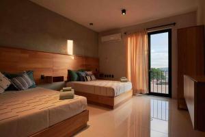 a bedroom with two beds and a large window at Casa Boutique Peñasco Oaxaca in Oaxaca City +62 photos