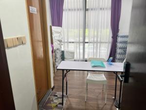 uma mesa e cadeiras num quarto com uma janela em Capital O 90985 Margo Hotel KK em Kota Kinabalu