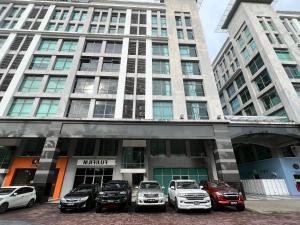 un grupo de coches estacionados frente a un edificio en Capital O 90985 Margo Hotel KK en Kota Kinabalu