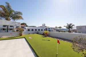 Una imagen del patio trasero de una casa con un putting green. en Sun Centre 9, en Plettenberg Bay