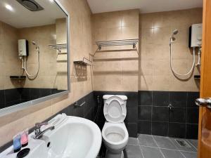 a bathroom with a sink and a toilet and a mirror at Capital O 90985 Margo Hotel KK in Kota Kinabalu