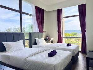 two beds in a hotel room with large windows at Capital O 90985 Margo Hotel KK in Kota Kinabalu