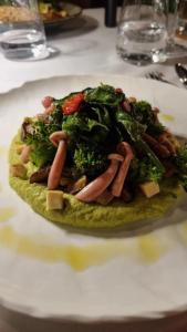 a plate of food with broccoli and sausage on a table at Dimitile Hôtel & Spa in LʼEntre-Deux