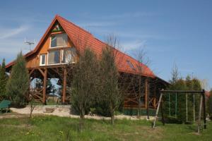 a large wooden house with a red roof at Dom letniskowy ORCHIDEA in Chrzanowo +40 photos