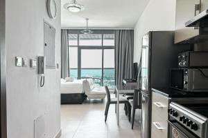 ドバイにあるStoneTree - Furnished Studio - Amazing Viewのベッド、テーブル、椅子が備わるホテルルームです。