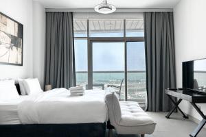 um quarto com uma cama, uma secretária e uma janela em StoneTree - Furnished Studio - Amazing View no Dubai