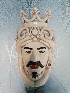 a statue of a mask with a crown on its head at Lazy Olives in Tongeren