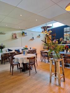 una sala da pranzo con tavoli e sedie in un ristorante di Rekerlanden 177 Vakantiewoning nabij Strand a Warmenhuizen