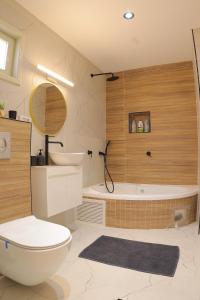 uma casa de banho com um WC, um lavatório e uma banheira em אחוזת דולב-הצימר em Bet Shemesh