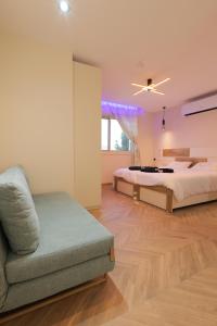 una grande camera da letto con un letto e un divano di אחוזת דולב-הצימר a Bet Shemesh