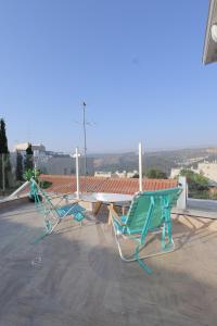 due sedie e un tavolo in cima a un tetto di אחוזת דולב-הצימר a Bet Shemesh
