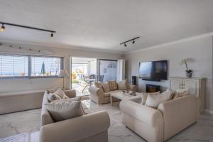Una gran sala de estar con sofás y un televisor. en Sun Centre 9, en Plettenberg Bay
