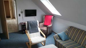 a living room with two chairs and a tv at Ferienwohnung Klausing 15153 in Leer