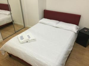 ein Bett mit zwei weißen Handtüchern darüber in der Unterkunft Grosvenor house in Cardiff