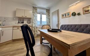 a kitchen and dining room with a wooden table and chairs at Villa Pauline - FeWo “Provence“ in Bad Sooden-Allendorf