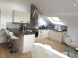 a kitchen with white cabinets and a counter top at Grosvenor house in Cardiff