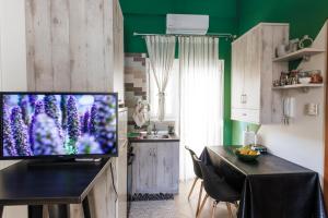 a living room with a television and a table with chairs at Cozy studio Anastasia-spotless-quiet-Free private garage in Kozani