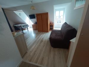 a living room with a couch and a wooden floor at Studio classé 4 personnes face aux Thermes, avec coin nuit in Le Mont-Dore +9 photos