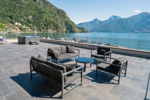 eine Terrasse mit Gartenmöbeln und Seeblick in der Unterkunft Villa Navalia in Menaggio