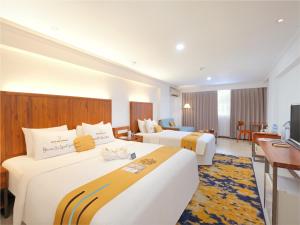 Habitación de hotel con 2 camas y TV en Metro Park View Hotel Kota Lama Semarang, en Semarang