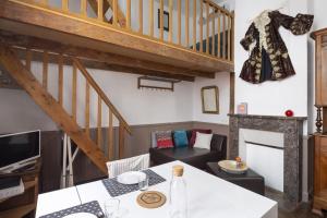 a living room with a table and a staircase at Le Petit Mont by Cocoonr in Rennes