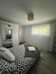 sypialnia z czarno-białym łóżkiem i oknem w obiekcie Apartament Guziczek w Nowym Targu