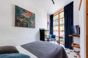 een slaapkamer met een bed, een tv en een raam bij House of Sun in Vilnius