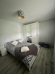 sypialnia z dużym łóżkiem i lustrem w obiekcie Apartament Guziczek w Nowym Targu
