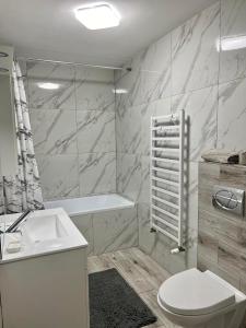 łazienka z toaletą, umywalką i wanną w obiekcie Apartament Guziczek w Nowym Targu