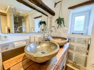 a bathroom with two sinks on a wooden counter at Altes Backhaus in der Eifel in Feuerscheid