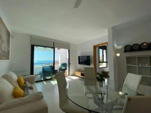 a living room with a glass table and chairs at Comfortable House in Mojácar with Shared Pool in Mojácar