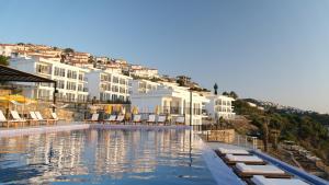 a large swimming pool with chairs and buildings at Ni Marin Hotel in Milas