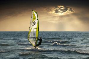 un hombre está haciendo windsurf en el océano en ONYM Curated Villas en Plaka