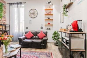een woonkamer met een leren bank en een tafel bij Panurban Rooms by Wonderful Italy in Palermo