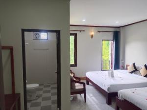 1 dormitorio con 1 cama y baño con aseo en Dokchampa Hotel en Vang Vieng
